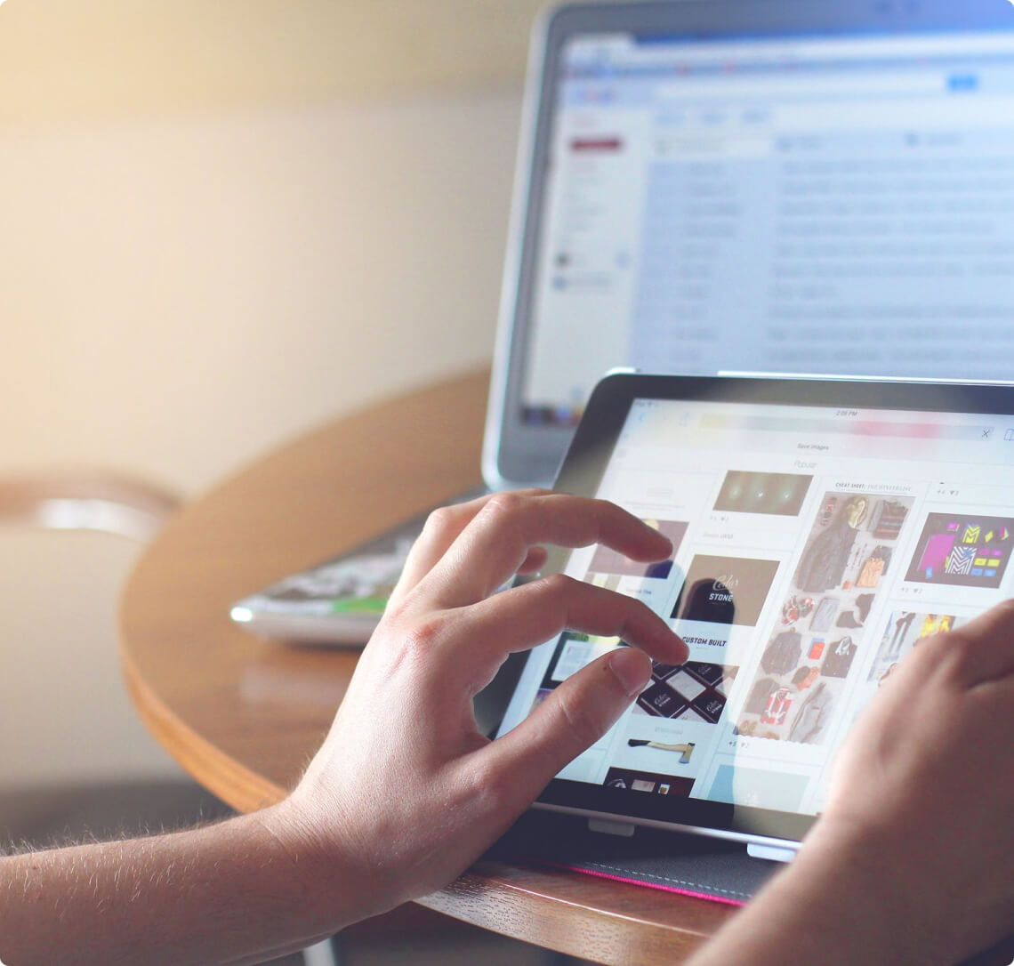 A person using an iPad on a table for social media advertising.