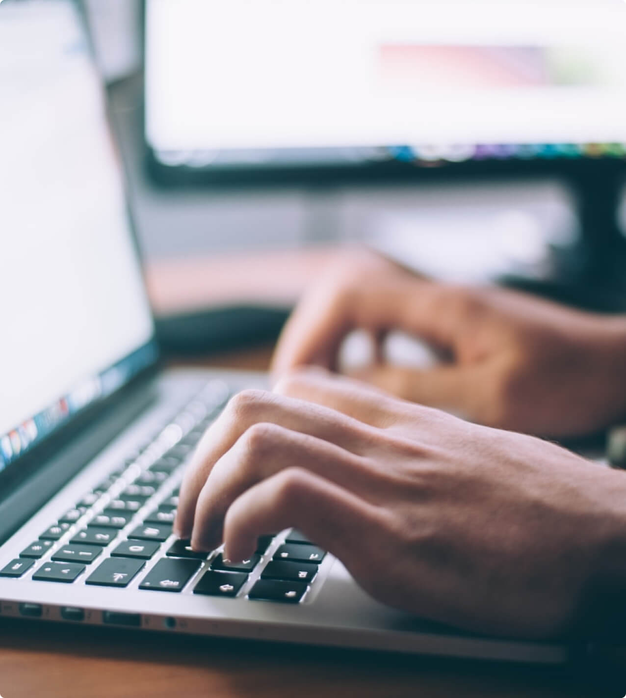 A person is typing on a laptop computer at a PPC Agency.