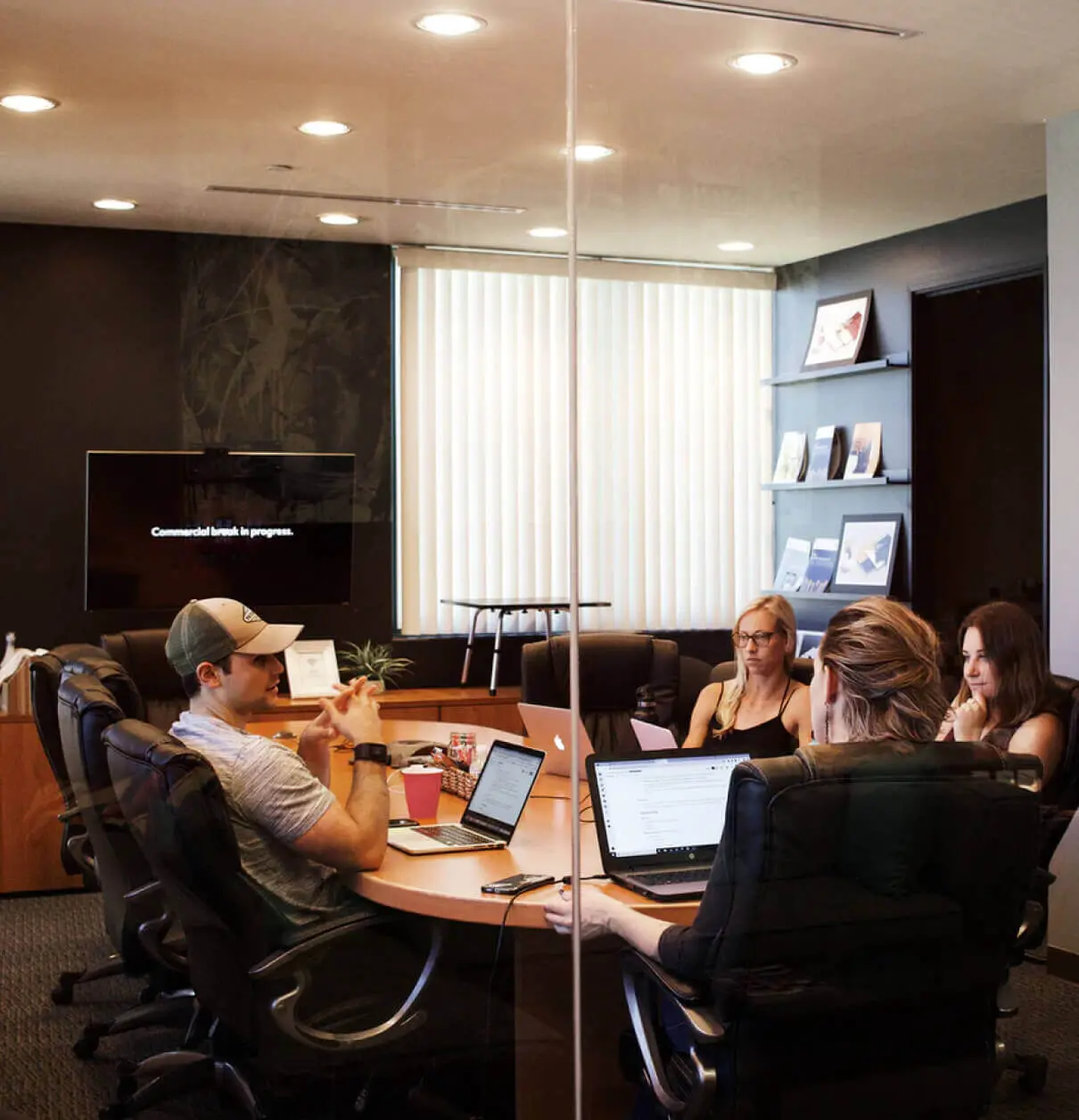 A group of people sitting around a table in a conference room discussing data visualization.