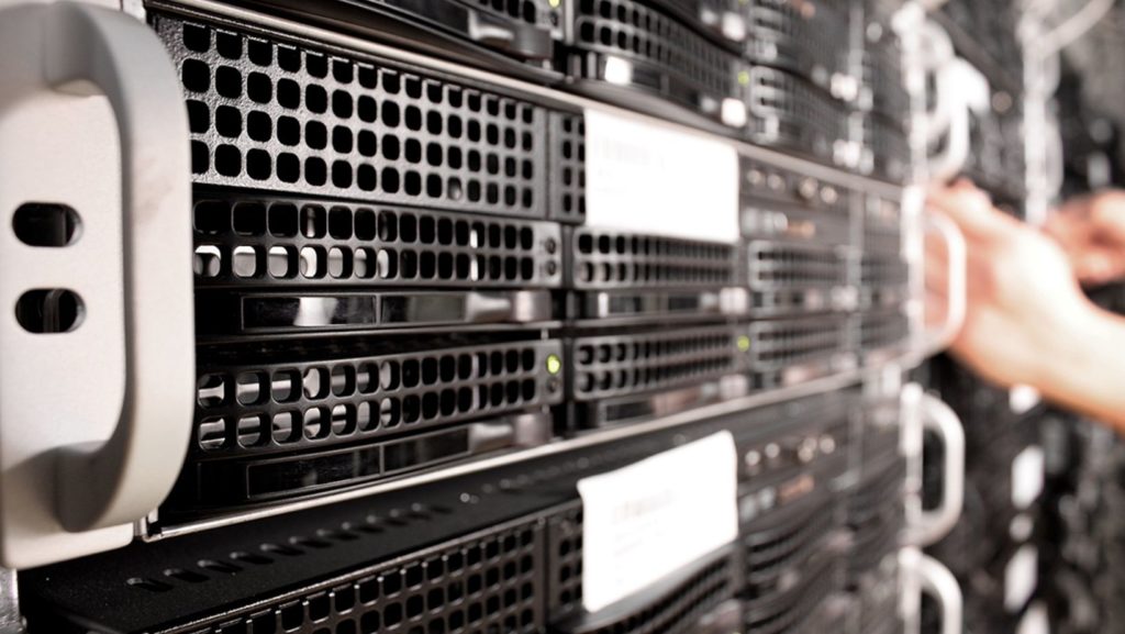 A person is working on a server in a data center to ensure proper optimization.